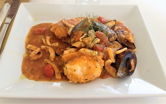 Plato de pescado y mariscos en salsa en Maklas